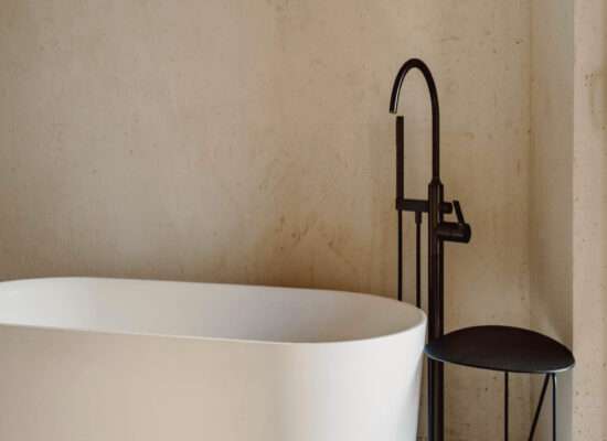 Ściana z mikrocementu w łazience z białą wanną